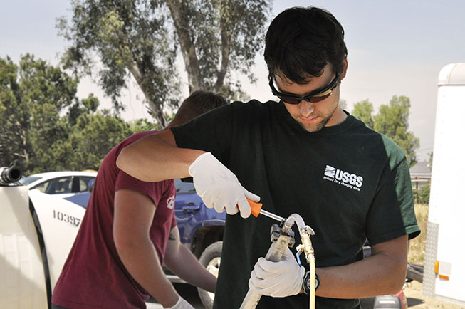 Photo of a USGS hydrologist preparing equipment during groundwater sampling in Jurupa Valley, California.